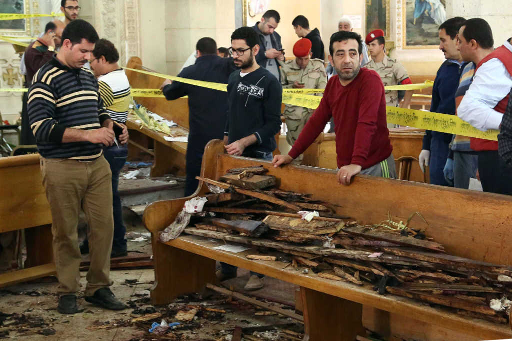 A general view shows forensics collecting evidence at the site of a bomb blast which struck worshippers gathering to celebrate Palm Sunday at the Mar Girgis Coptic Church in the Nile Delta City of Tanta (Photo credit: STRINGER/AFP/Getty Images)