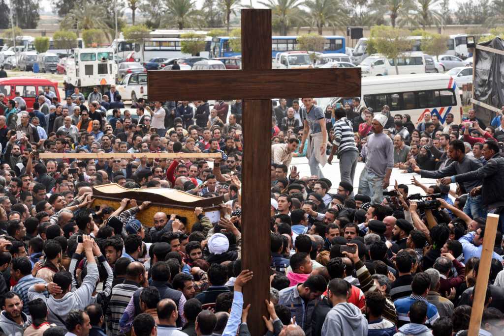 Mourners carry a large cross and the coffin of one of the victims of the blast at the Coptic Christian Saint Mark's church (Photo credit: MOHAMED EL-SHAHED/AFP/Getty Images)