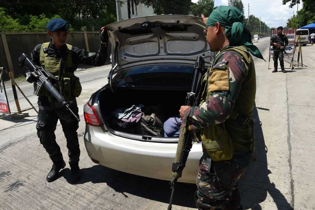 Philippine policemen check a car boot of a resident fleeing from Marawi city, where gunmen who had declared allegiance to the Islamic State group rampaged through the southern city, at a checkpoint in Iligan City, in southern island of Mindanao on May 24, 2017. Philippine President Rodrigo Duterte warned that martial law would be "harsh" and like a dictatorship, after imposing military rule in the south of the country to combat Islamist militants. / AFP PHOTO / TED ALJIBE (Photo credit should read TED ALJIBE/AFP/Getty Images)