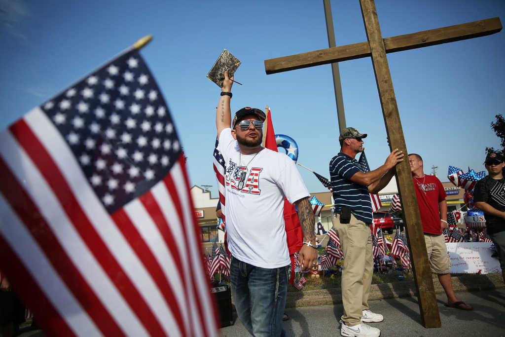 CHATTANOOGA, TN - JULY 19 : Evangelist Andrew Green from the Highways and Hedges Ministry preaches near the Armed Forces Career Center/National Guard Recruitment Office which had been shot up on July 19, 2015 in Chattanooga, Tennessee. . The gunman Mohammod Youssuf Abdulazeez, 24, opened fire on the military recruiting station at the strip mall on July 16th and then drove more than seven miles away to an operational support center operated by the U.S. Navy and killed four United States Marines and a Navy sailor. The gunman was likely killed in a exchange of gunfire with the police. (Photo by Joe Raedle/Getty Images)