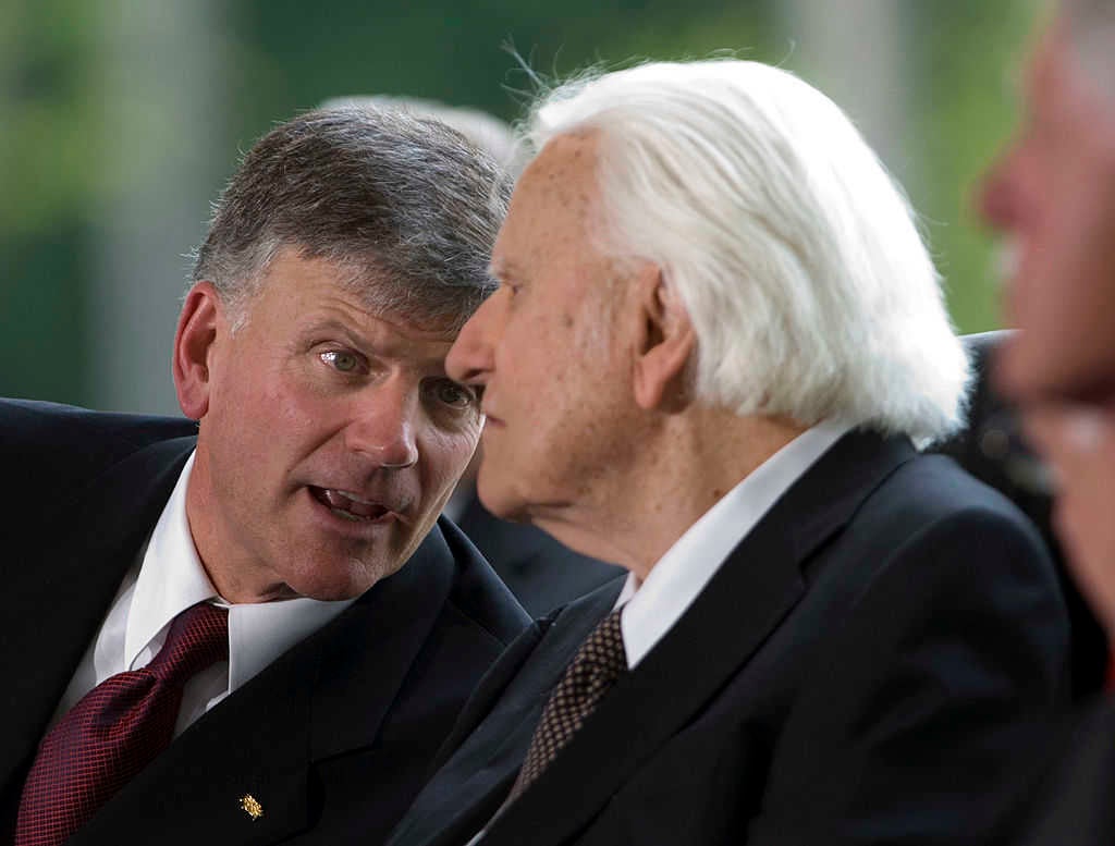 Franklin Graham (L) talks to his father Billy Graham on the stage during the Billy Graham Library Dedication Service on May 31, 2007 (Davis Turner/Getty Images)