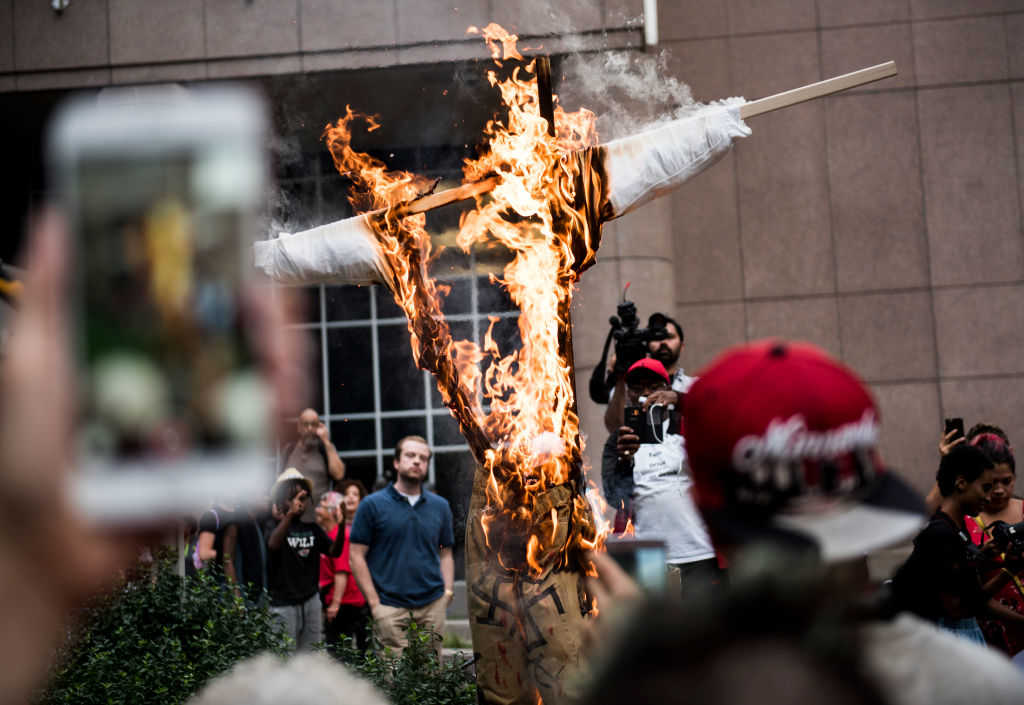 An effigy of U.S. President Donald Trump, dressed in khakis and a white shirt covered in swastikas, is set ablaze during a protest against racism and the violence over the weekend in Charlottesville, Virginia on August 14, 2017 in Minneapolis, Minnesota. (Stephen Maturen/Getty Images)