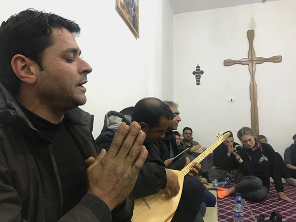 New Syrian Christians sing a prayer with traditional Kurdish guitar. (Photo credit: Free Burma Rangers)