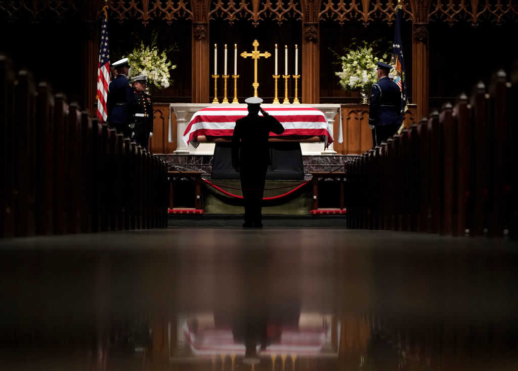 A member of the military salutes the flag-draped casket of former President George H.W. Bush as it lies in repose at St. Martin's Episcopal Church on December 5, 2018 in Houston, Texas. (Photo by David J. Phillip-Pool/Getty Images)