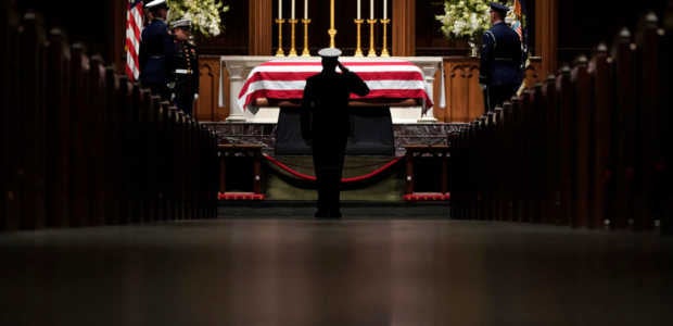A member of the military salutes the flag-draped casket of former President George H.W. Bush as it lies in repose at St. Martin's Episcopal Church on December 5, 2018 in Houston, Texas. (Photo by David J. Phillip-Pool/Getty Images)