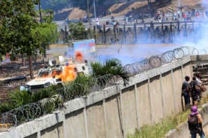 Demonstrators throw petrol bombs to military forces at the air force base La Carlota on April 30, 2019 in Caracas, Venezuela. (Photo by Edilzon Gamez/Getty Images)